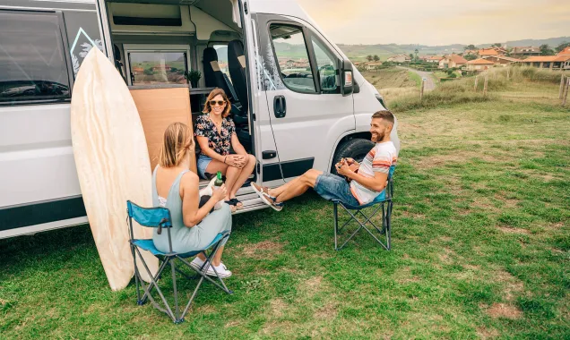 friends relaxing outside their camper 